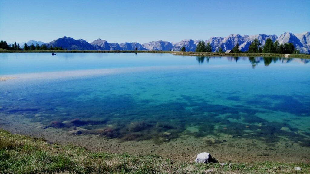 Aussichtsbild großer blauer See mit weitläufigen Bergen im Hintergrund