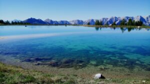 Aussichtsbild großer blauer See mit weitläufigen Bergen im Hintergrund