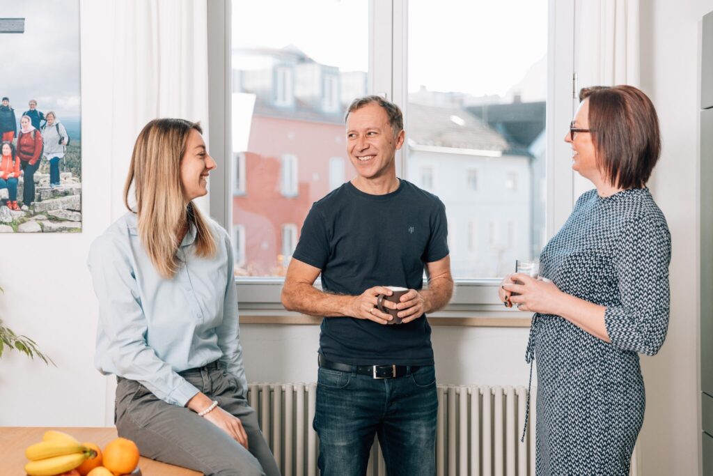 Günther Holzapfel und Daniela Ettl im Gespräch mit einer Teamleiterin der Lohnabrechnung von aipama